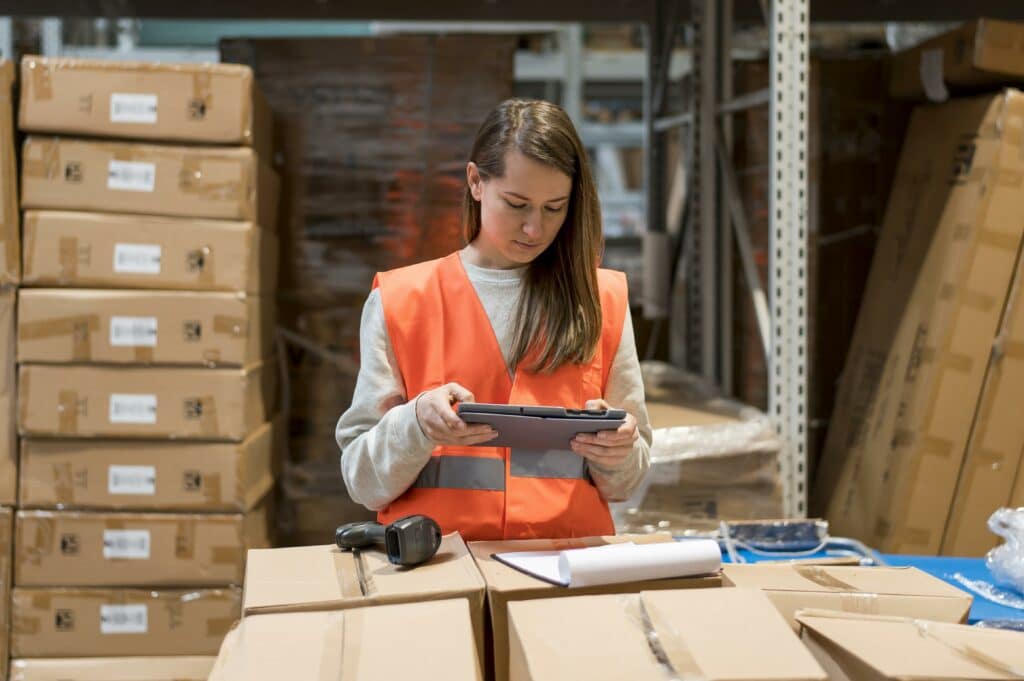 femme avec tablette d'un entrepôt de stockage